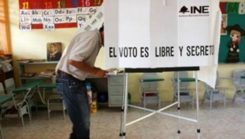 Un hombre vota en una cabina electoral