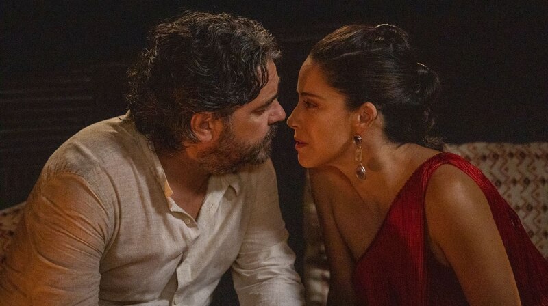 Una pareja se besa apasionadamente en una noche oscura.