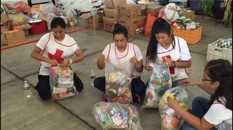 Voluntarias de la Cruz Roja empaquetando alimentos para los damnificados