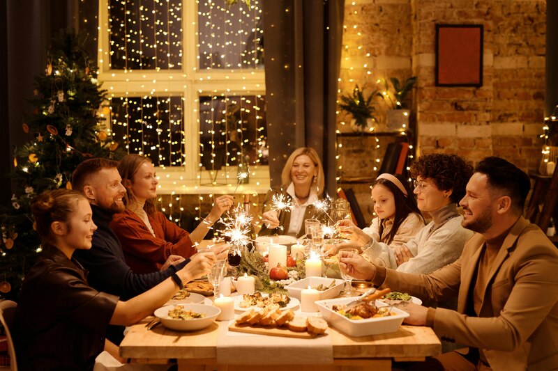 Familia cenando y celebrando la Nochebuena con bebida y luces de bengala.