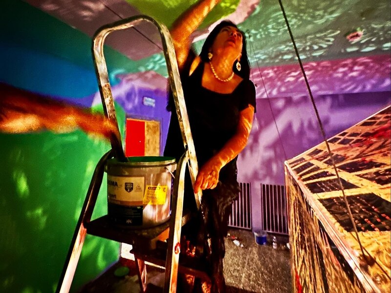 Artista pinta un mural en una galería