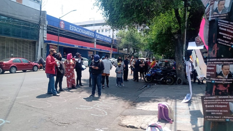 Multitud reunida en la calle con pancartas y carteles.