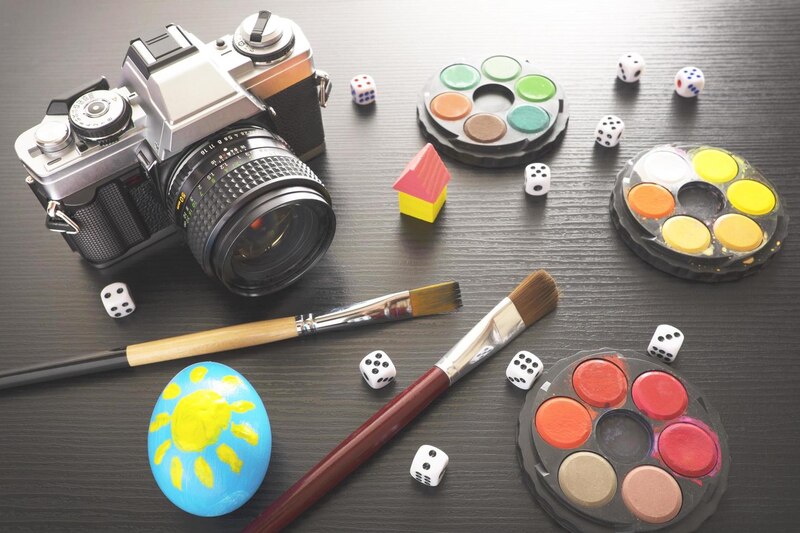 Cámara, dados, pinceles y pinturas