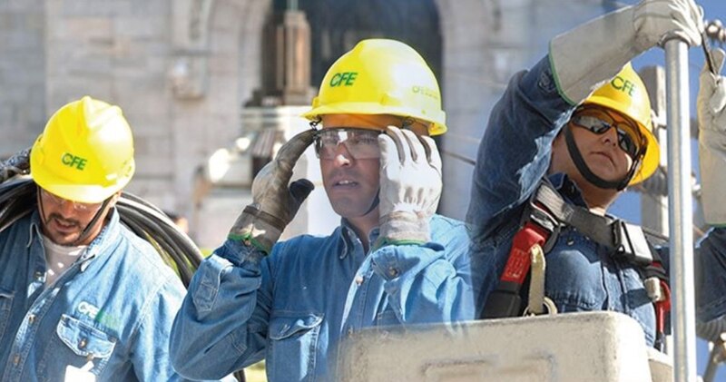 Trabajadores de la CFE realizando labores de mantenimiento en una línea eléctrica.