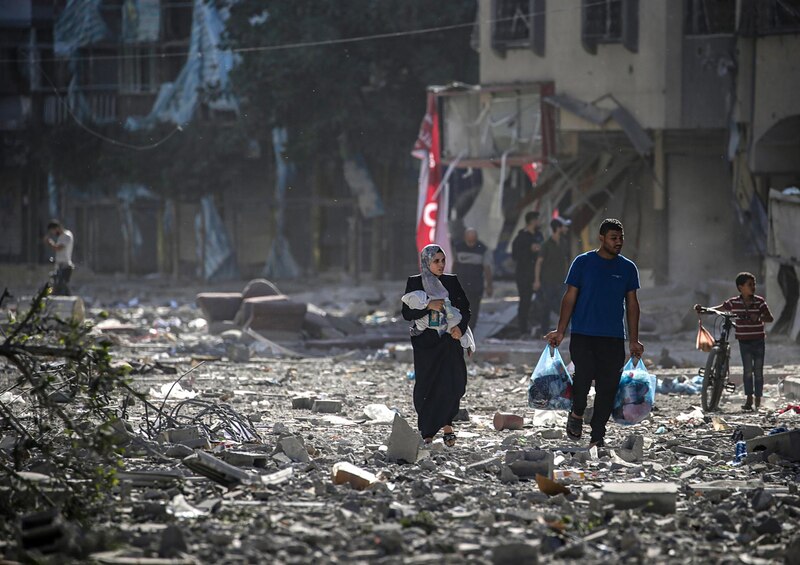Madre e hijo caminan entre los escombros de la guerra