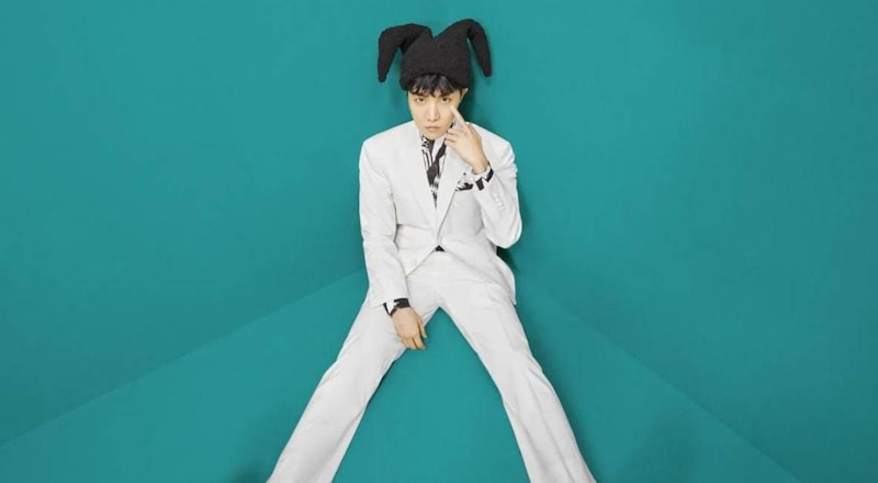 El cantante J-Hope de BTS con un traje blanco y orejas de conejo.