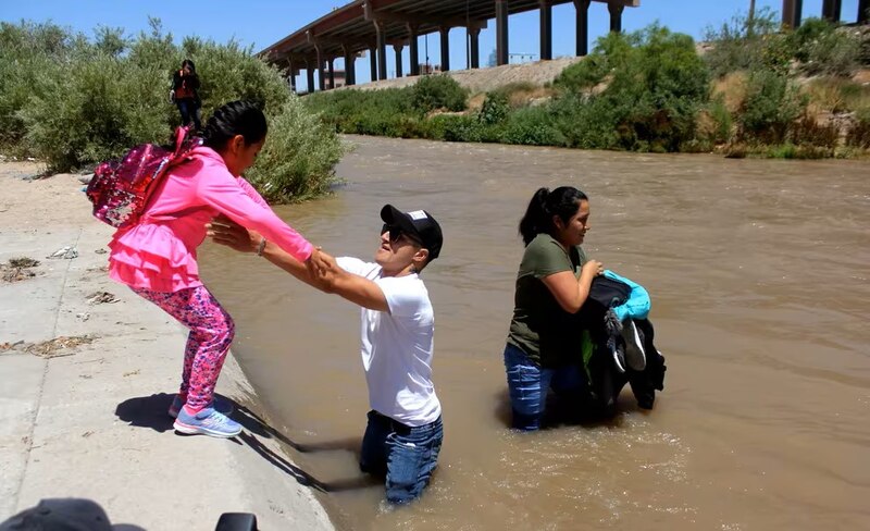 Familia migrante cruza el río Bravo