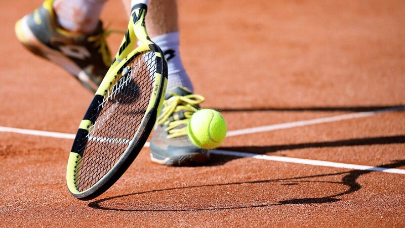 Jugador de tenis golpeando la pelota con su raqueta
