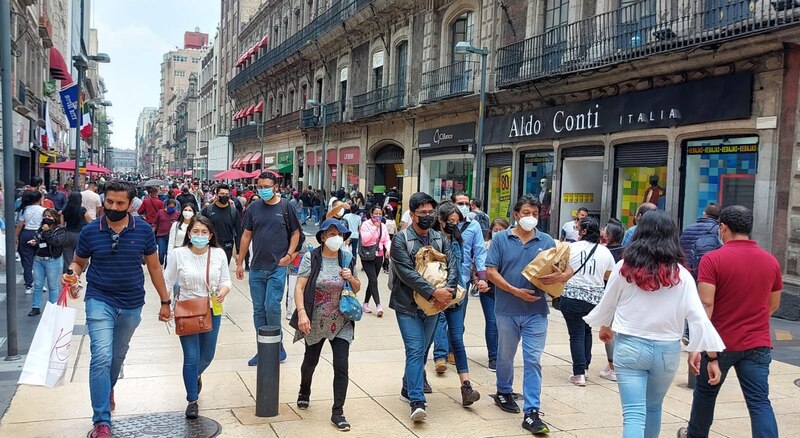 Multitud de personas caminando por una calle en el centro de la ciudad