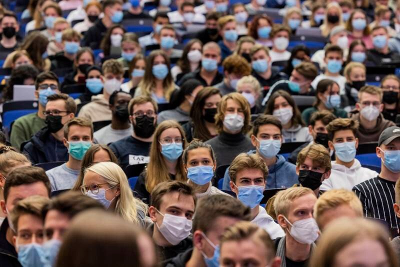 Estudiantes universitarios con mascarillas en una conferencia