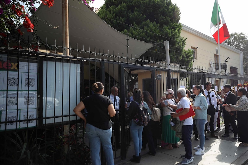 Larga fila de personas esperando para entrar a un edificio