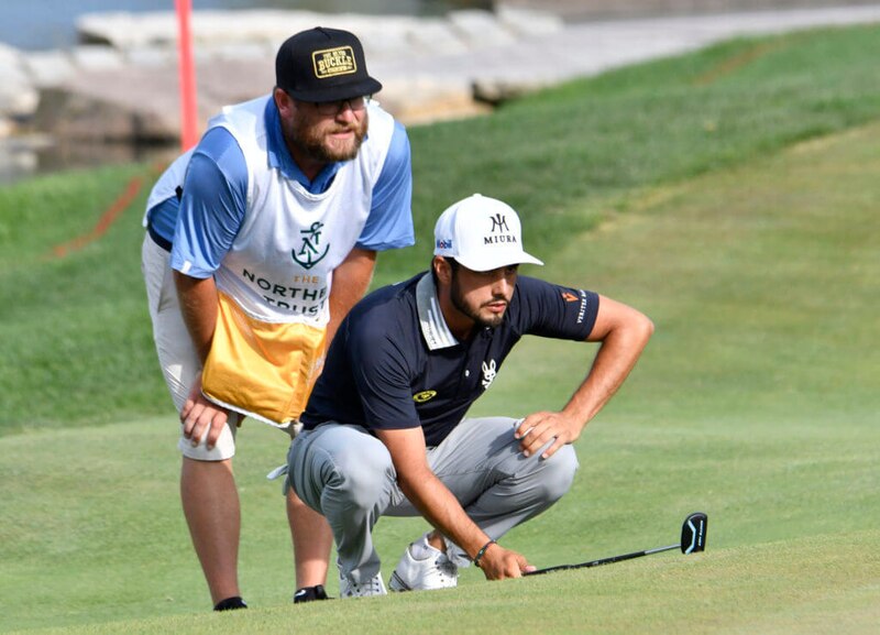 Golfista profesional con su caddie en el green