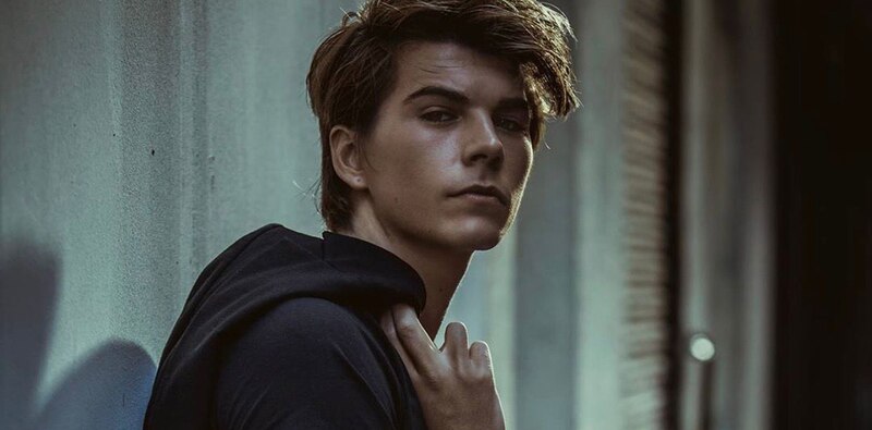 Joven modelo masculino con cabello castaño y ojos azules