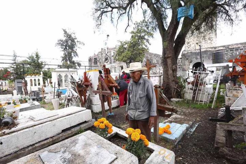 Un hombre arreglando tumbas en un cementerio