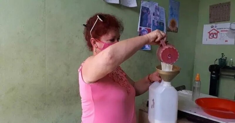 Mujer vierte un líquido de un recipiente a otro