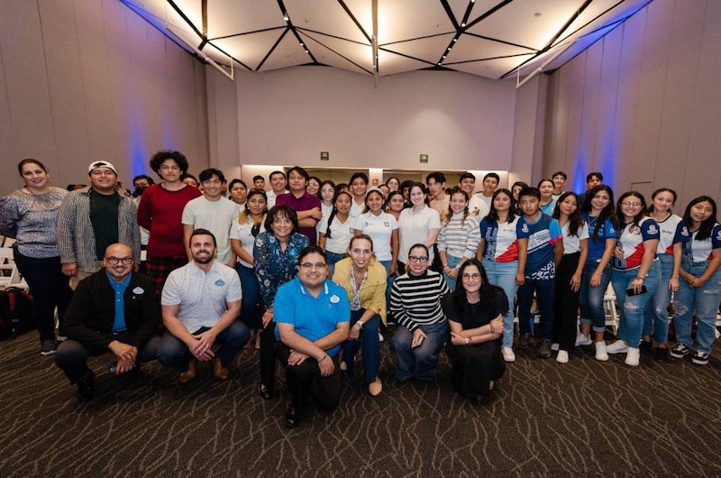 Un grupo de jóvenes estudiantes sonríe para una foto grupal.