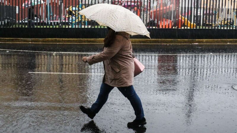 Mujer camina bajo la lluvia