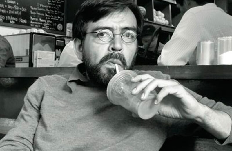 Un hombre bebe de un vaso con una pajita