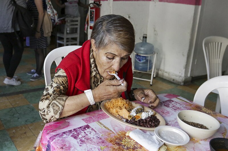 Anciana comiendo en un comedor social