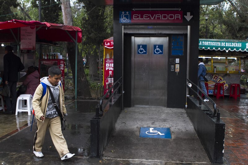 Un niño camina por una rampa para discapacitados hacia un elevador en la Ciudad de México.