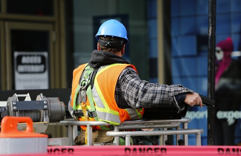 Trabajador de la construcción en una cesta elevadora