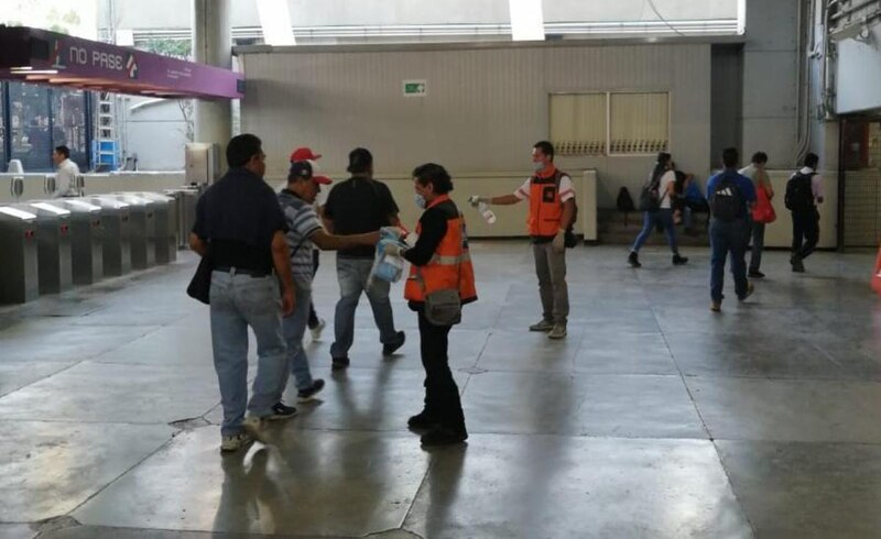 Estación de metro con personas usando cubrebocas
