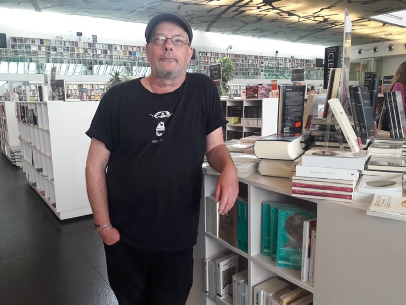 El escritor español Arturo Pérez-Reverte en una biblioteca