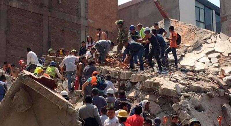 Rescatistas buscan sobrevivientes entre los escombros de un edificio colapsado