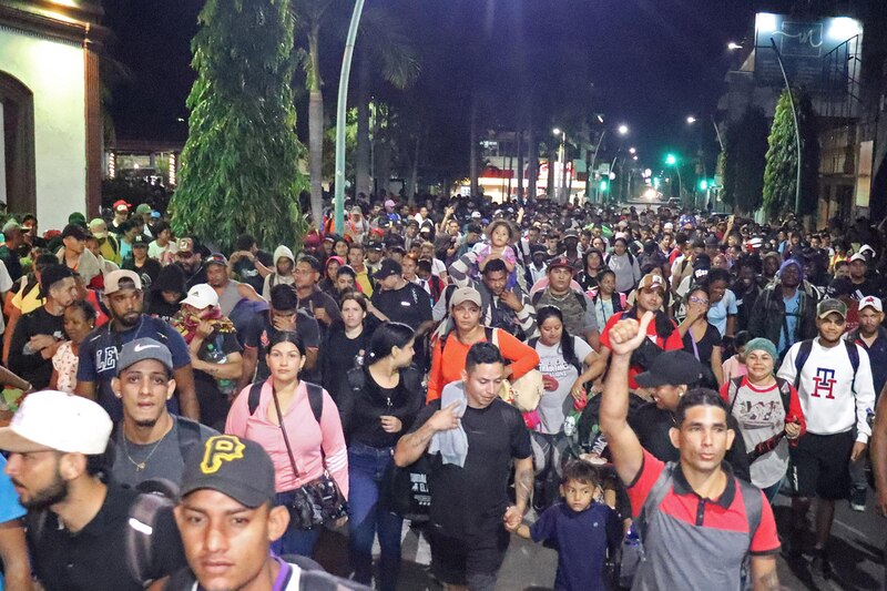 Grupo de migrantes caminando por una carretera en el sur de México con mochilas y pertenencias, rumbo a la frontera norte