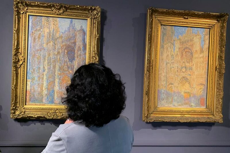 Mujer mirando dos cuadros de Monet