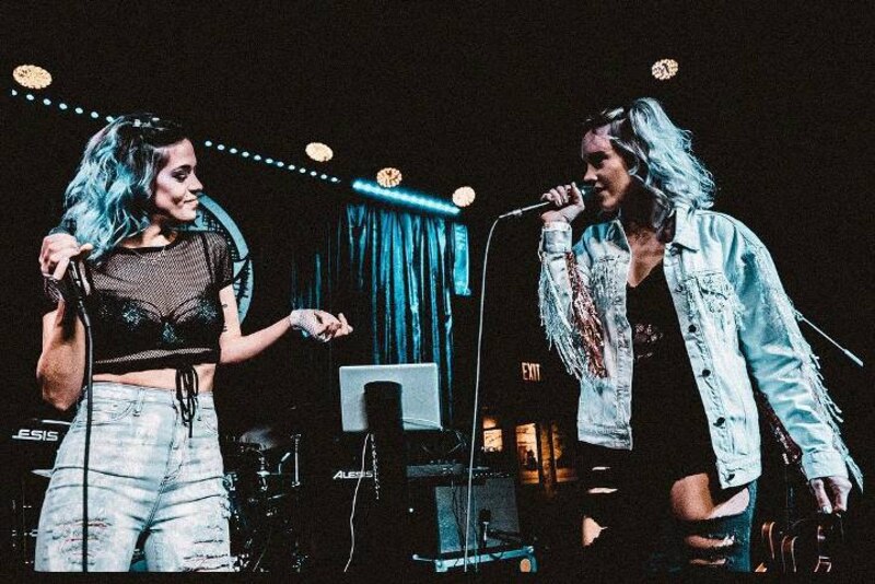 Dos mujeres cantando en un bar