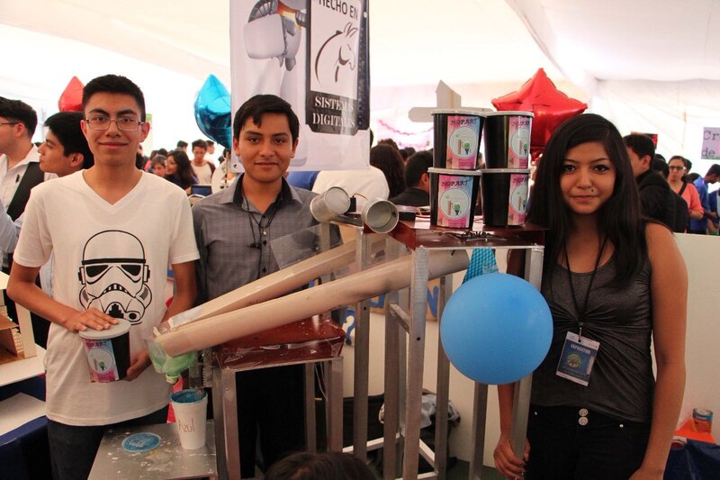 Estudiantes de secundaria muestran su proyecto de ciencias en una feria de ciencias.