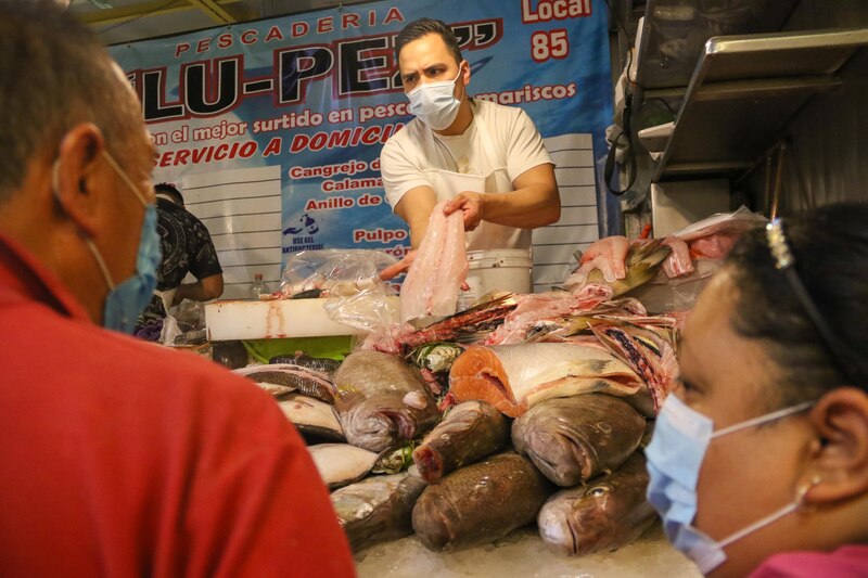 Hombre vendiendo pescado en una pescadería