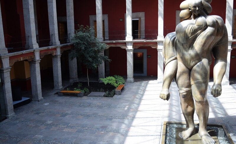 Escultura de mujer en el patio de un museo