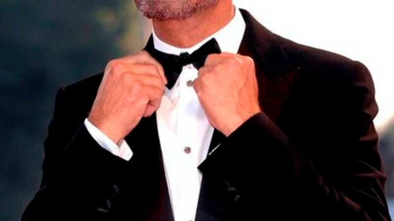 El actor George Clooney se arregla el nudo de la pajarita