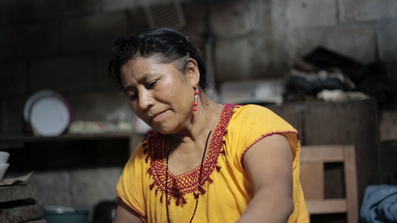 Mujer indígena cocina en su casa
