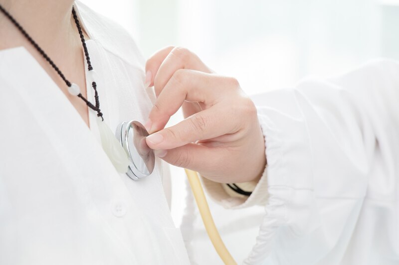 Doctora auscultando el corazón de un paciente con un estetoscopio