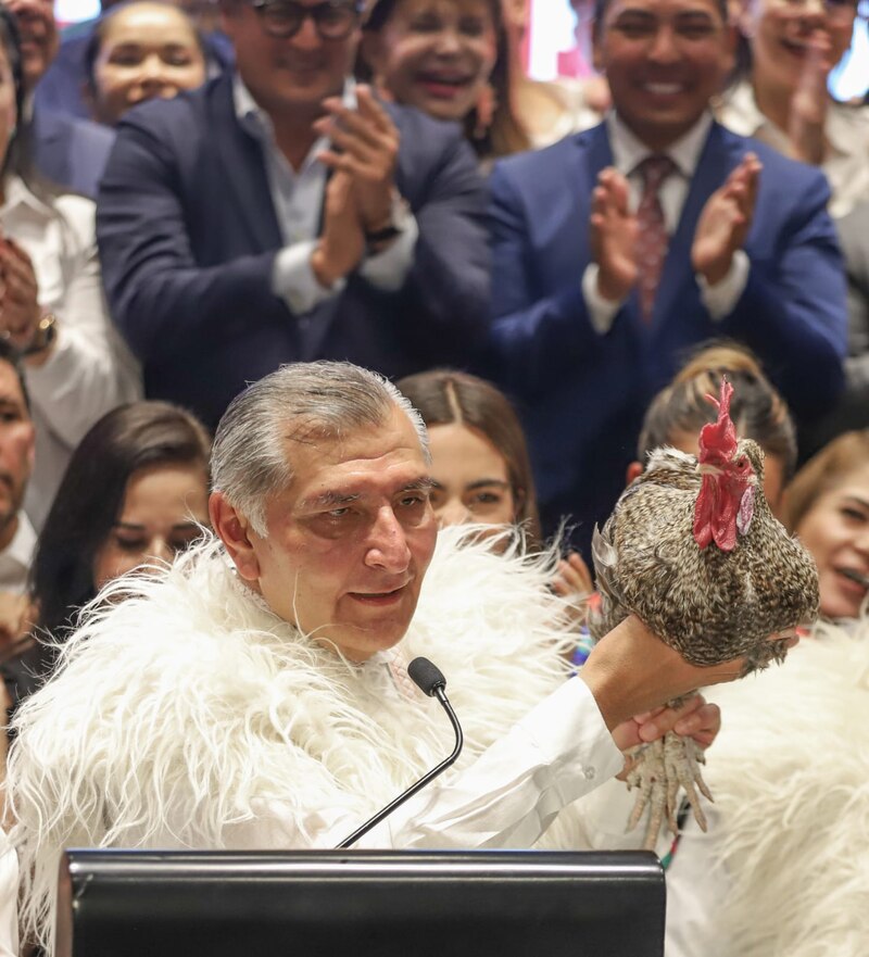 Político sosteniendo un gallo