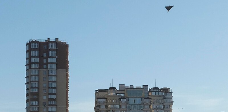 Un avión no tripulado vuela sobre dos edificios de apartamentos en la ciudad.