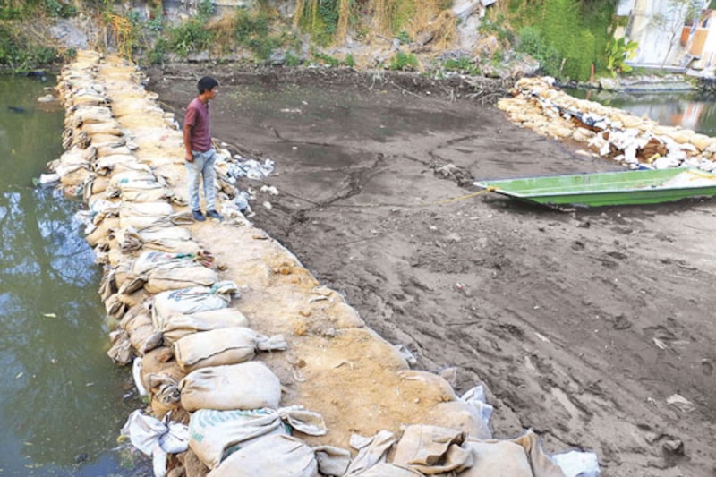 Un hombre observa un río contaminado
