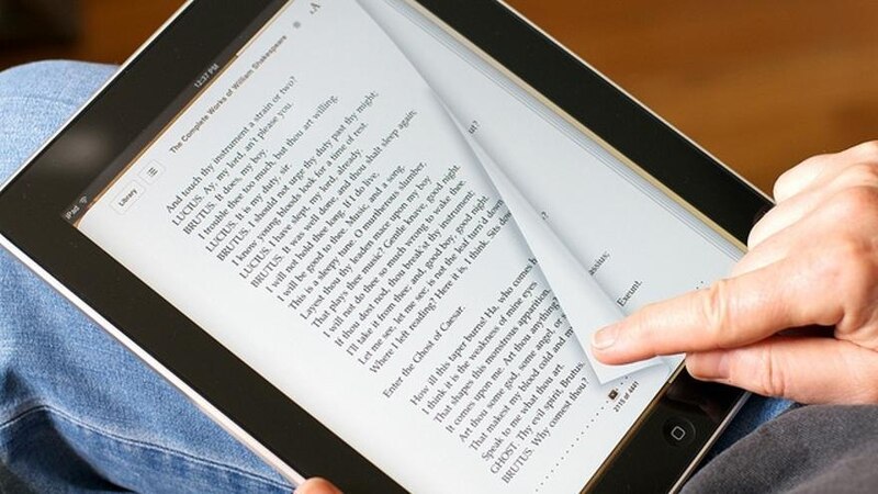 Un hombre leyendo un libro en una tableta