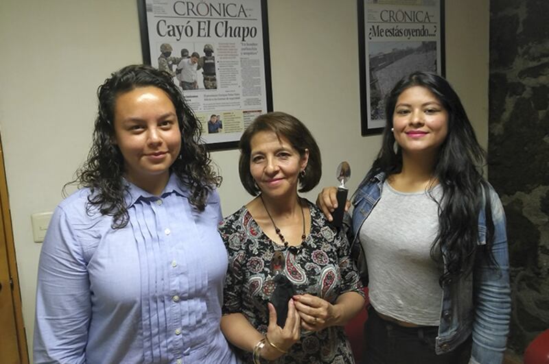 Tres mujeres sonríen para una foto.