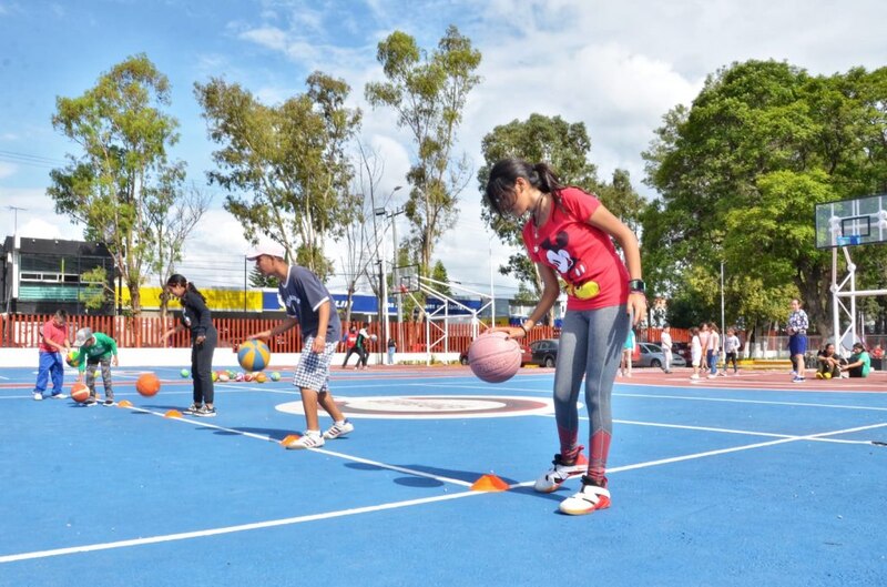 Niños jugando baloncesto en una cancha