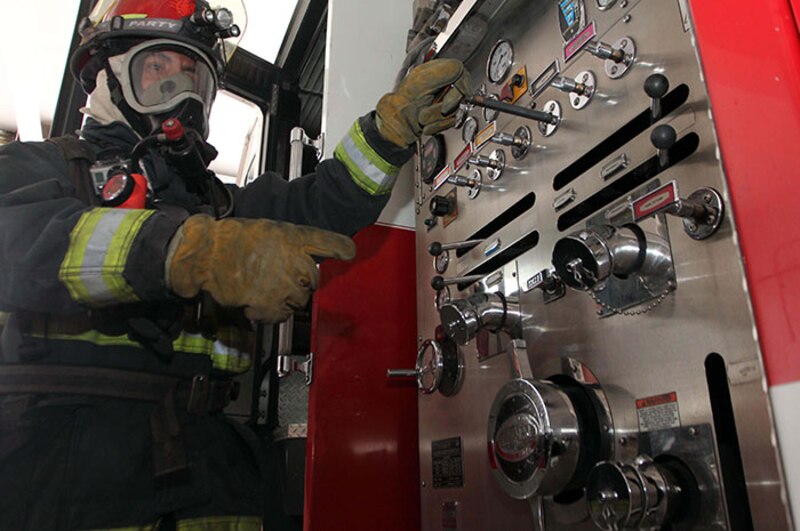 Bombero opera panel de control de camión de bomberos