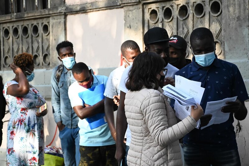 Migrantes esperan en la calle para solicitar asilo en España
