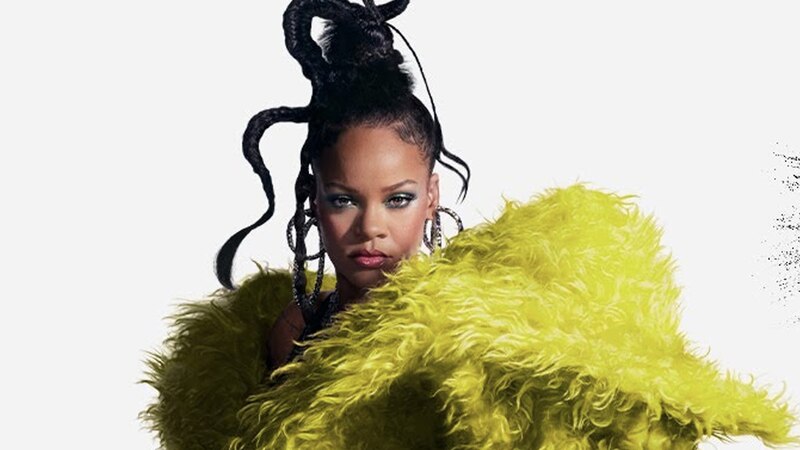 Rihanna con un abrigo de piel amarillo y un peinado afro