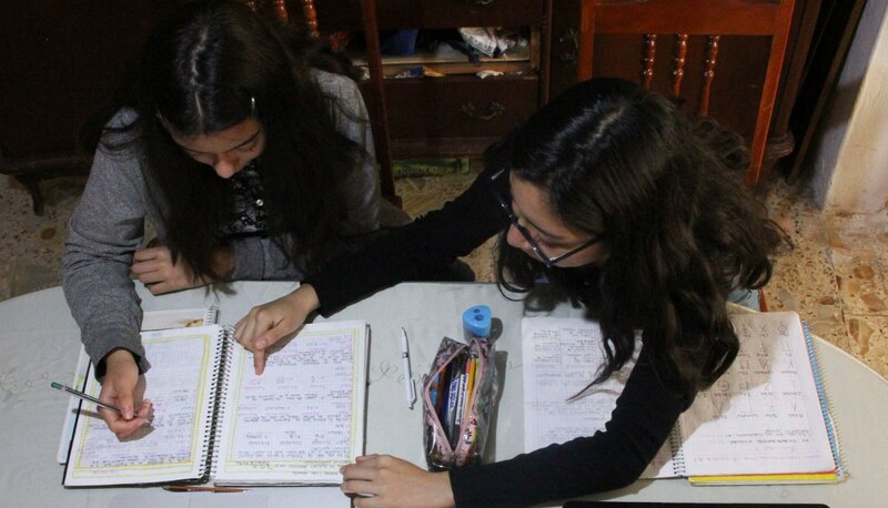 Dos niñas hacen sus deberes en casa