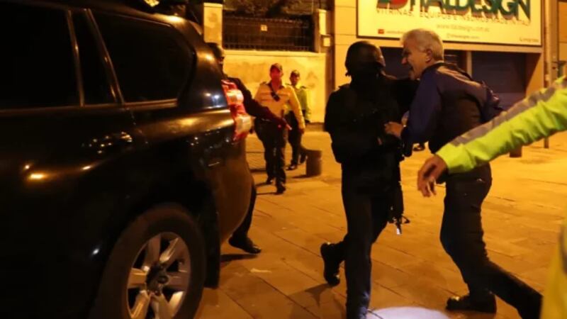 La policía detiene a un sospechoso en una calle oscura.