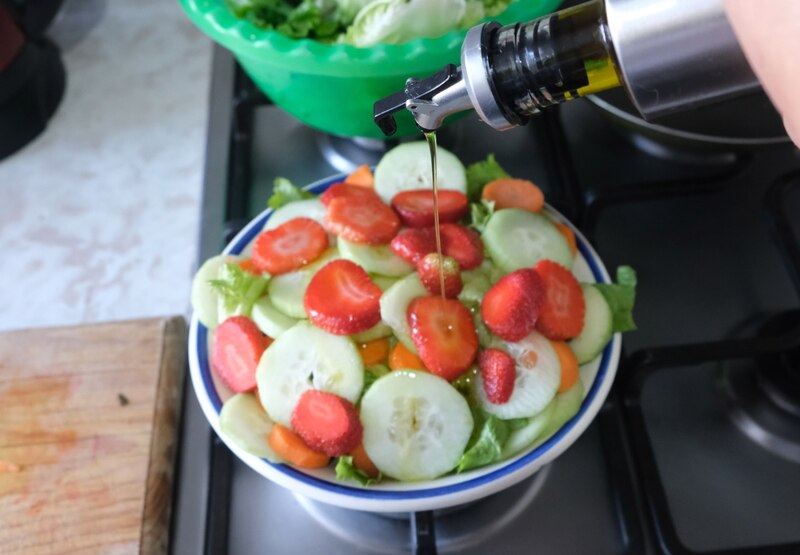 Una ensalada saludable con fresas, pepino, zanahoria y lechuga