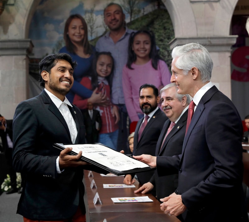 El presidente López Obrador entrega un reconocimiento a un joven indígena